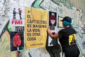 Foto de una parte de la pegatineada de una de las jornadas en Rosario.  "El capitalismo es basura la vida es otra cosa"