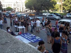 Fotografía de la peatonal feminista organizada en 7 y 50 con motivo del 8 de marzo de 2012. Pueden verse algunas mesas y mantas en el suelo sobre las cuales hay banderas, volantes, artículos para vender, entre otras.