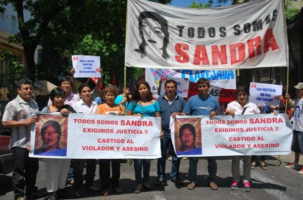 Fotografía de la cabecera de la movilización en el marco del juicio por el femicidio de Sandra Ayala Gamboa. En la imagen puede verse la bandera "Todas somos Sandra" y otras de organizaciones sociales y políticas de la época.