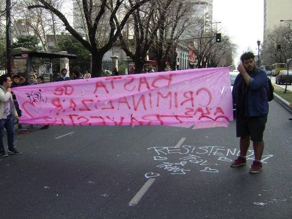 Fotografía de la manifestación por la persecución en la zona roja. En la imagen puede verse la bandera "basta de criminalizar a las travestis" y "resistencia trava y trans"