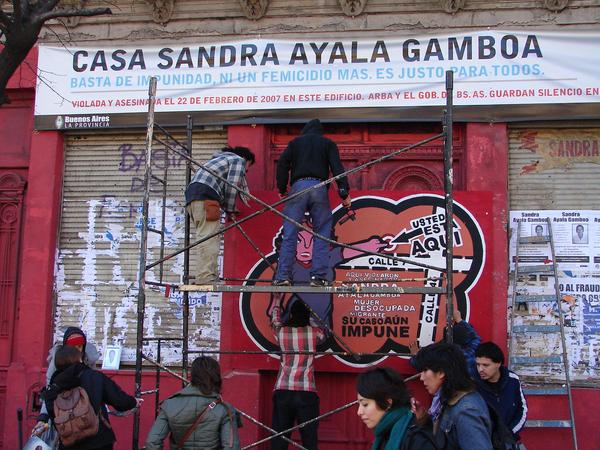 Banner que imita señalización oficial de ARBA, renombrando el lugar del femicidio como Casa Sandra Ayala Gamboa
