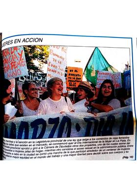 Cabecera de la manifestación. En primer plano, los rostros de cinco personas. De fondo, carteles con consignas alusivas a la fecha.