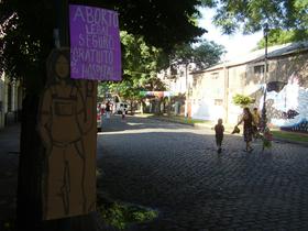 Fotografía de intervención por el Día Internacional de las Mujeres 2011. En el barrio Meridiano V, hecho en cartón y pegado en un árbol, una figura humana sosteniendo un cartel con la frase "Aborto legal, seguro, gratuito en el hospital"
