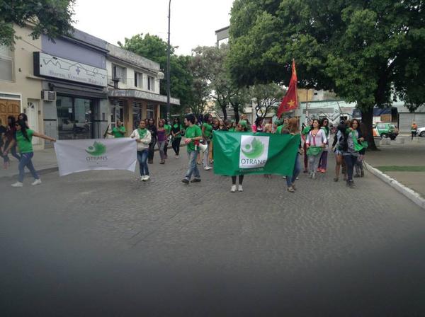 Fotografía de la cabecera de la manifestación por el hostigamiento, persecusión y amenazas en la zona roja de la ciudad. En la imagen puede verse encabezando la movilización dos banderas de OTRANS.